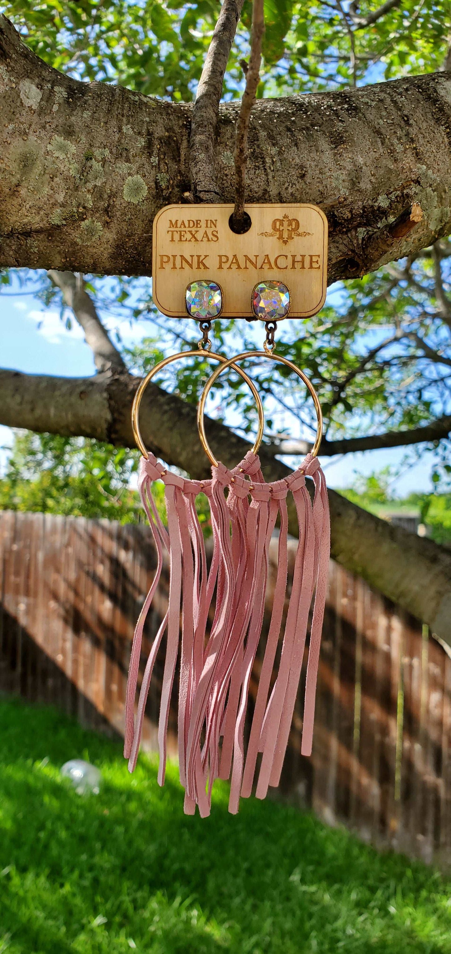 Jeweled and hoop earrings with pink fringe.