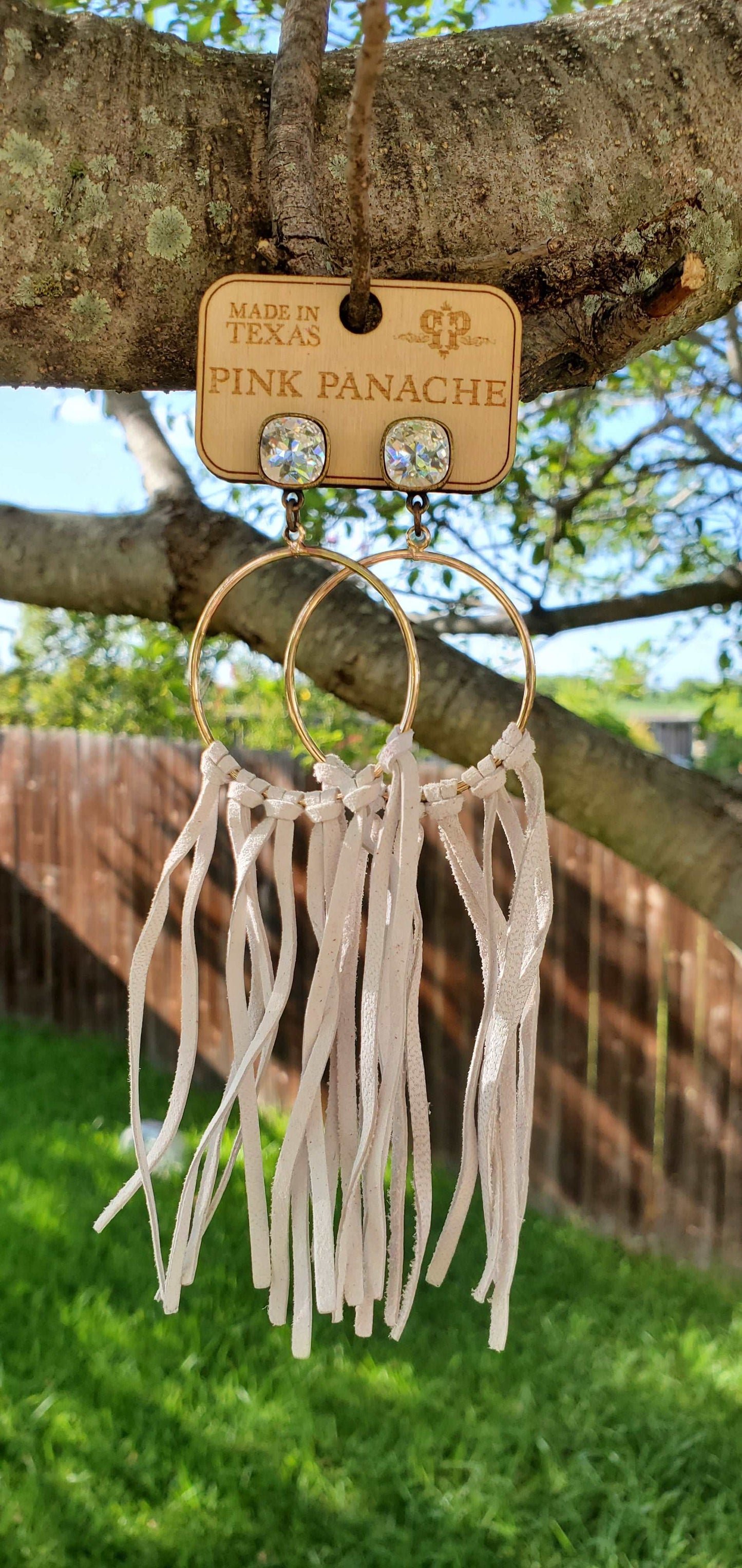 Jeweled and hoop earrings with white fringe.